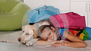 Girl with her dog prepared for school, lying on carpet