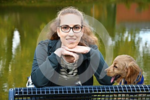 Girl and her dog resting on a bench