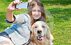 Girl and her dog selfie summer on a background of green grass.