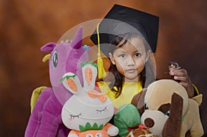 girl and her doll. Girls graduation photo. a girl in a graduation costume