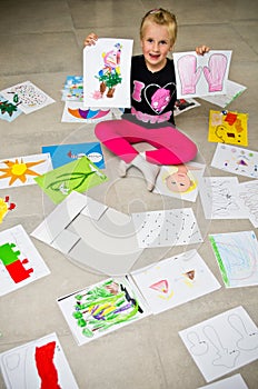 Girl with her drawings on the floor