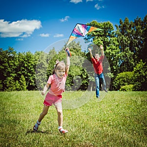 The girl and her father play with a kite.