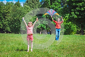 The girl and her father play with a kite.