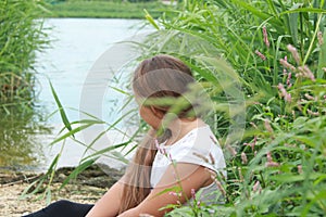 Girl with her hair down on the river on a summer day