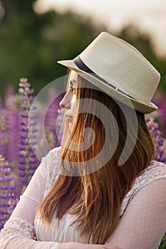 Girl with her hair looks at the setting sun.