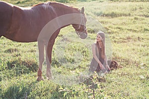 Girl and her horse on the sunlit field