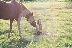 Girl and her horse on the sunlit field