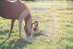 Girl and her horse on the sunlit field