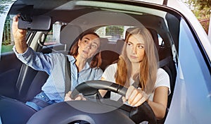 Girl and her mother during driving lesson in a car