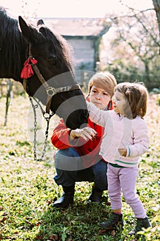 Girl and her mother feeding horse