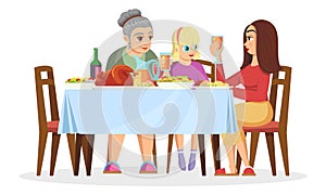 Girl, her mother, grandmother sitting at table, chatting, eating, celebrating holidays.