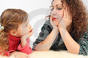 Girl and her mother lies on fell, hands on chin photo