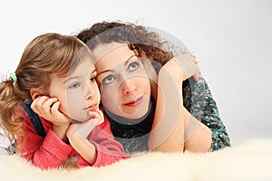 Girl and her mother lies on fell, hands on chin photo