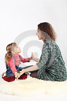 Girl and her mother sitting on white fell photo
