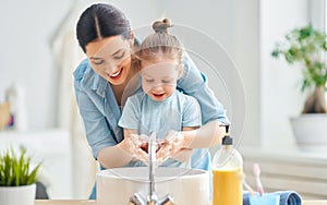 Girl and her mother are washing hands