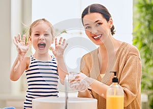 Girl and her mother are washing hands