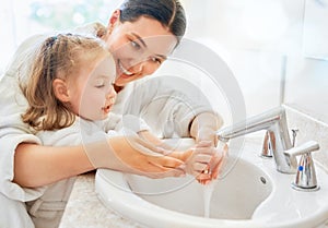 Girl and her mother are washing hands