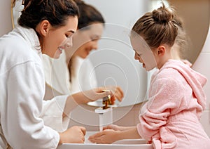 girl and her mother are washing hands