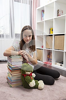 Girl in her room, with a lot of book
