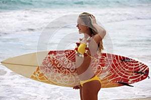 Girl with her surfboard at the beach