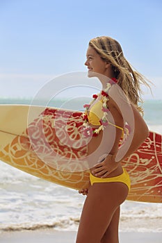 Girl with her surfboard at the beach
