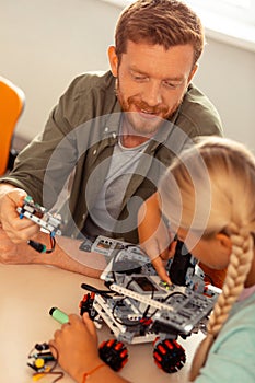 Girl and her teacher turning on the robotic car.