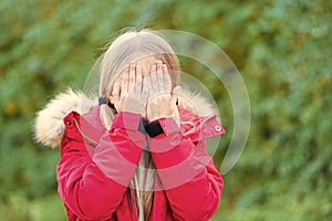 Girl hide face with hands on idyllic autumn day