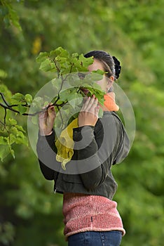 Girl hiding behind a branch