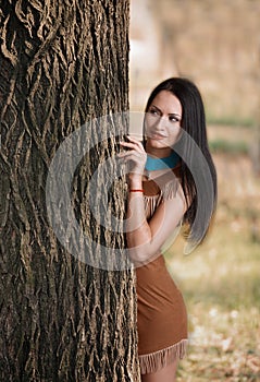 Girl hiding behind a tree