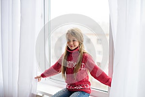 Girl hiding behind window white transparent curtain in afternoon. Quarantine home