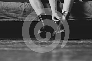 Girl in high black boots on the old dirty floor at home, women`s shoes, feet in shoes on the floor, shoes