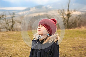 Girl high in the mountains with eyes closed