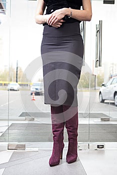 Girl in high red boots, a coat in the office