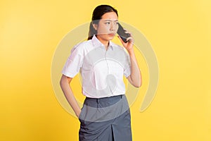 girl in high school uniform receiving phone call with smartphone