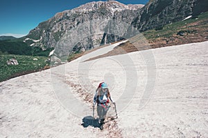 Girl hiker climbing on mountains glacier with backpack