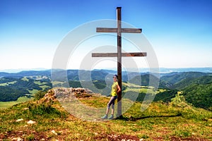 Girl hiker posing with cross on top of the hill Strazov in Slovakia