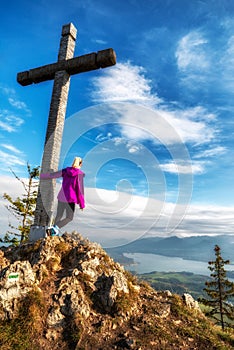 Girl hiker posing with wooden cross on top of the hill Pravnac in Slovakia