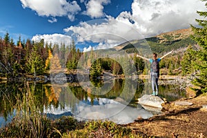 Girl hiker on the shore of mountain lake Rakytovske pliesko in High Tatras mountains in Slovakia