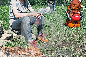 A girl in hiking boots, enjoying the rest in the camping.