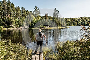 Girl hiking in the Forest near lake in La Mauricie National Park Quebec, Canada on a beautiful day