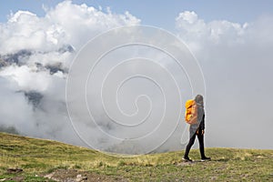 Girl hiking in the Pyrenees, with the mountains in the clouds in the background photo