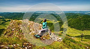 Dívka turistika sedí na vrcholu kopce Strážov s krásnou krajinou. Slovensko