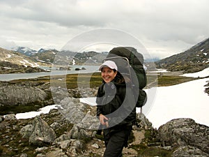 Girl hiking in snowfield and rockfield