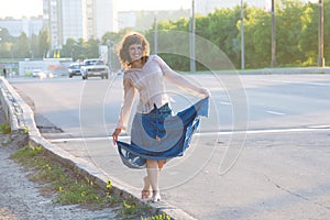 Girl, hippie, walking on side of carriageway