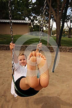 Girl with her feet together in the air swinging photo