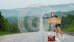 Girl hitchhiking holds up a sign