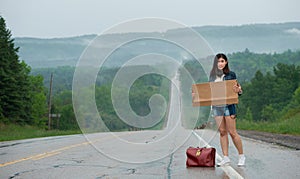 Girl hitchhiking holds up a sign