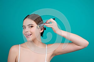 Girl hold blush blusher apply powder visage isolated over studio background. Woman powdering cheeks. Makeup brush photo