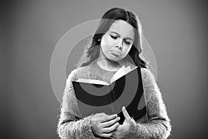 Girl hold book read story over orange background. Child enjoy reading book. Book store concept. Wonderful free childrens