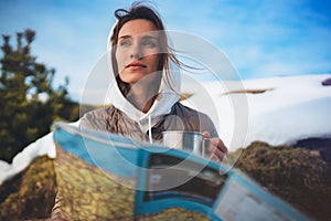 Girl hold in hands cup of drinks, relax tourist look on map, people planning trip in snow mountain, hipster enjoy on background